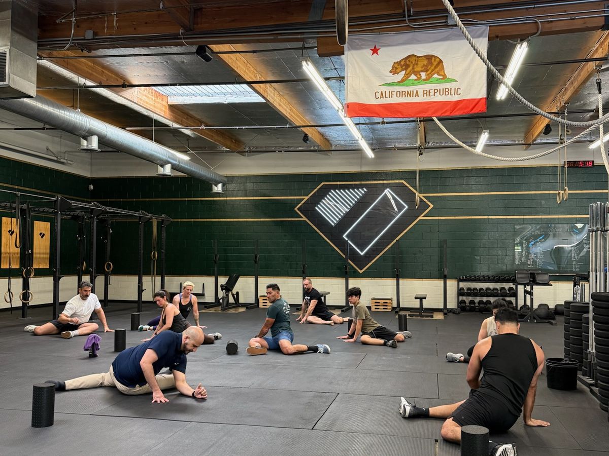 Group doing floor mobility work at a gym workshop